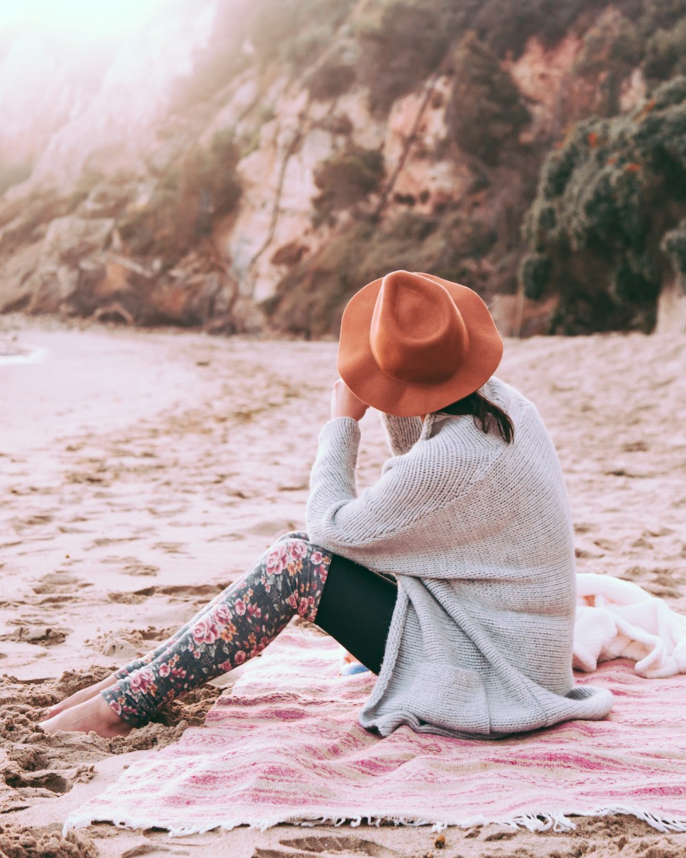 Woman relaxing on a Santa Barbara beach with coastal cliffs at golden hour